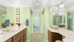 Bathroom featuring shower with separate bathtub and vanity