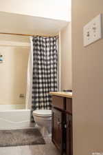 Full bathroom with vanity, toilet, tile patterned floors, and shower / bathtub combination with curtain