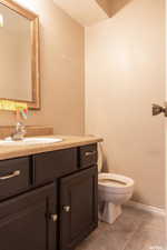 Bathroom with vanity, a textured ceiling, toilet, and tile patterned floors