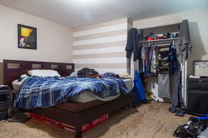 Carpeted bedroom featuring a textured ceiling