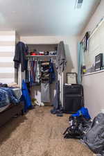 Carpeted bedroom with a closet and a textured ceiling