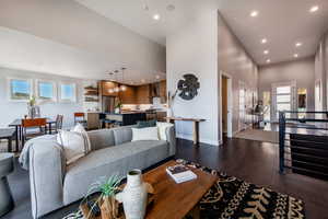 Living room featuring a towering ceiling and dark wood-type flooring