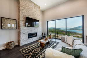 Living room featuring a fireplace, a high ceiling, and hardwood / wood-style flooring