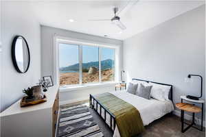 Carpeted bedroom with a mountain view and ceiling fan