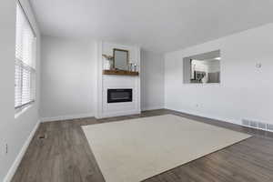 Unfurnished living room with a fireplace and wood-type flooring