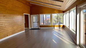 Unfurnished sunroom with wooden ceiling and lofted ceiling