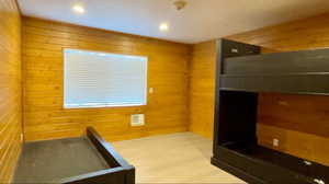 Interior space with wooden walls and hardwood / wood-style flooring