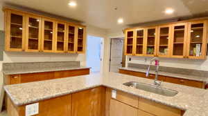 Kitchen featuring light stone countertops and sink