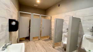 Bathroom featuring hardwood / wood-style floors, tile walls, and sink