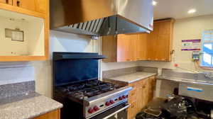 Kitchen featuring island range hood and range with gas cooktop