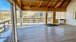 Unfurnished sunroom with lofted ceiling with beams, wood ceiling, and heating unit