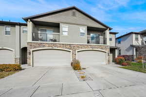 View of property featuring a balcony and a 2 car garage