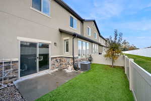 Rear view of house with central air condition and astro turf