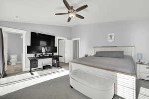 Primary Bedroom featuring connected bathroom, carpet floors, vaulted ceiling, and ceiling fan