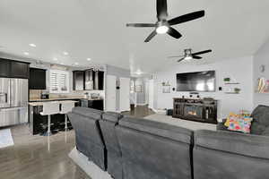 Living room featuring hardwood / wood-style flooring, ceiling fan, a fireplace, and sink