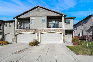 View of property with a balcony and a 2 car garage