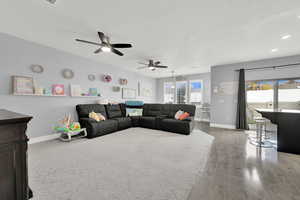 Living room with ceiling fan, wood-type flooring, and a textured ceiling