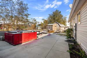 View of patio / terrace featuring outdoor lounge area, a hot tub, and a storage shed