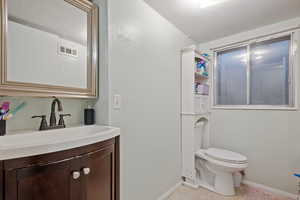 Bathroom featuring tile patterned flooring, vanity, and toilet