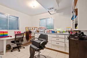 Office space with light tile patterned flooring and built in desk