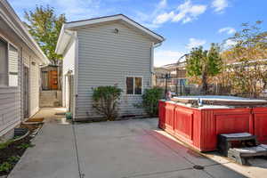 View of side of home with a patio and a hot tub