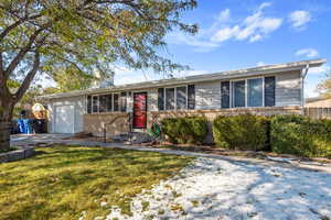 Single story home with a garage and a front lawn