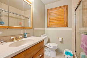 Bathroom featuring toilet, tile patterned flooring, vanity, and walk in shower