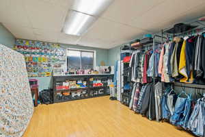 Spacious closet with a drop ceiling and hardwood / wood-style flooring