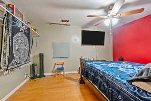 Bedroom featuring ceiling fan and hardwood / wood-style flooring