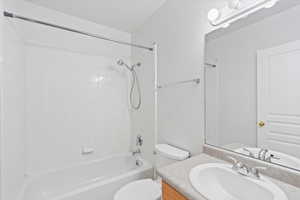 Full hall bathroom with vanity, toilet, and tiled shower / bath