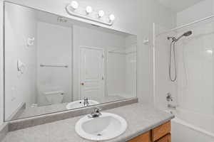 Full primary en suite bathroom with vanity, toilet, and tiled shower / bath combo