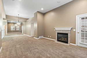 Large open concept with vaulted ceilings and gas fireplace. Glass door to a private balcony