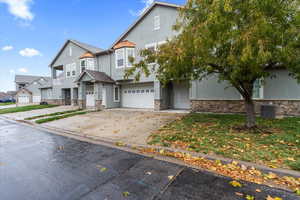 View of front of home featuring central AC unit and a garage