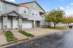 Front of unit with two car garage, covered entrance, and private balcony