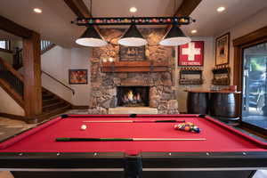 Rec room featuring bar area, a stone fireplace, and pool table