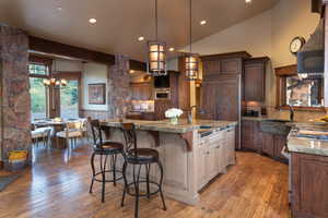 Kitchen with pendant lighting, a center island with sink, hardwood / wood-style flooring, and sink