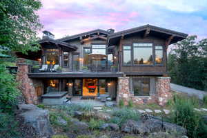 Back house at dusk featuring a balcony