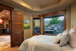 Bedroom featuring a raised ceiling and bar area