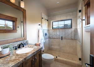 Bathroom with tile patterned flooring, vanity, toilet, and a shower with shower door