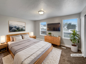 Carpeted bedroom featuring a textured ceiling and a baseboard radiator