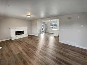 Unfurnished living room featuring dark hardwood / wood-style flooring and a fireplace