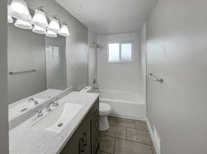 Full bathroom with tile patterned flooring, vanity, toilet, and tiled shower / bath