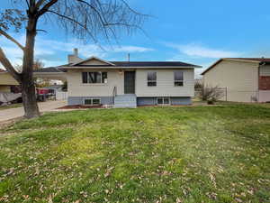 View of front of property with a front yard and a carport