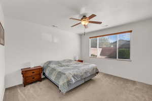 Carpeted bedroom with ceiling fan