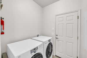 Laundry room featuring washing machine and dryer and light tile patterned floors