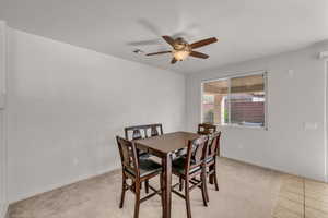 Carpeted dining area with ceiling fan and a textured ceiling