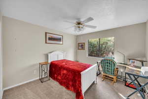 Bedroom featuring a textured ceiling, carpet floors, and ceiling fan