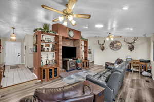 Living room featuring a textured ceiling, vaulted ceiling, and light wood-type flooring