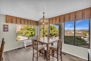 Dining space with wood-type flooring and an inviting chandelier