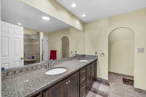 Bathroom featuring tile patterned floors, vanity, and an enclosed shower